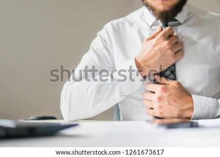 Businessman work with computer on table in office work. Financial business. Close up. Office work with a laptop. Light background. Smartphone in hand Young bearded businessman.
