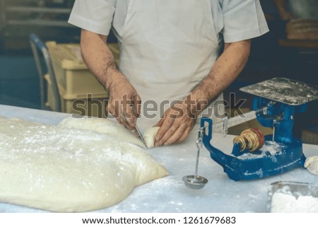 Bread chef Hand cutting the bread flour and balance on the scales machine in preparing step in Bakery kitchen