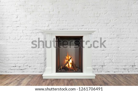 Burning classic fireplace of white marble. Empty living room on background.