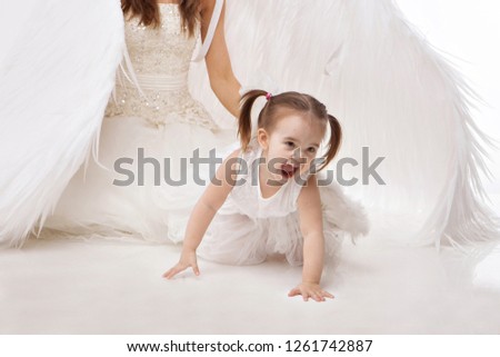 a woman and a girl in white dresses with angel wings on his back. Big and small angel on white background