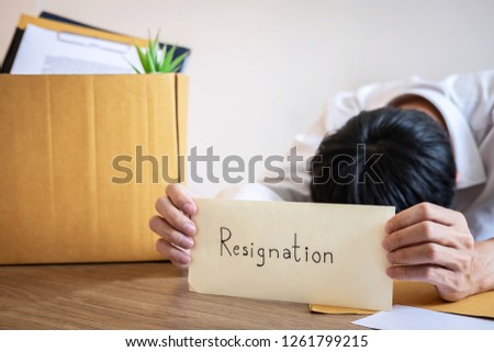 Stressed businessman will being resignation and packing belongings company and files into brown cardboard box, changing and resigning from work concept.