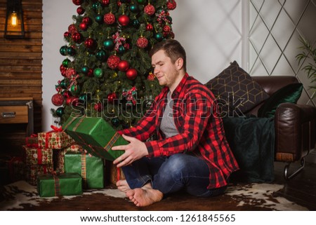 Guy celebrate Christmas and New Year at cozy home, concept of mans