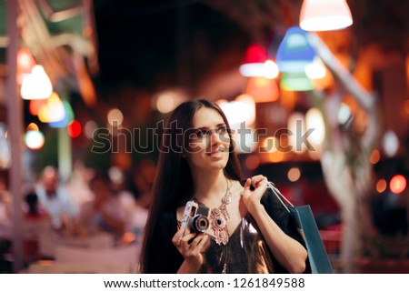 Happy Tourist Shopping in the Evening in the City. Cheerful woman gathering travel souvenirs and memories from vacation 
