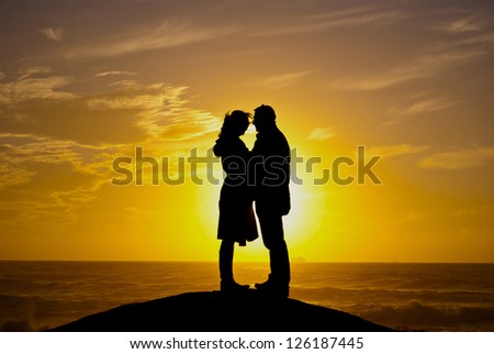 Silhouette of two people, men and women against the setting sun