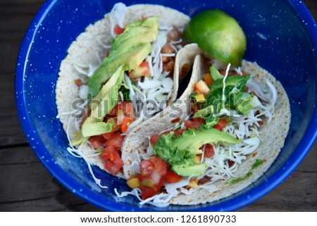 Bean Tacos with shredded cabbage, avocado, tomato, and lime