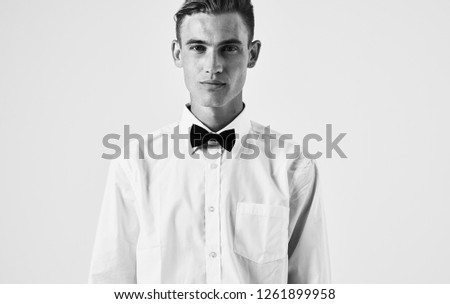 A man in a shirt and a bow tie around his neck               