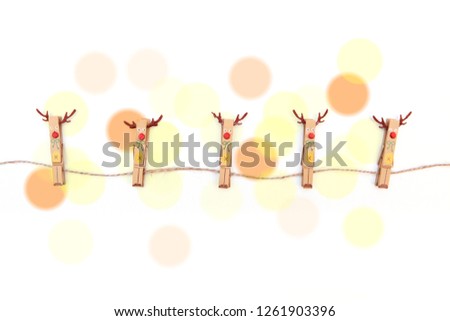 Christmas decorative pins on a string. White background, light circles.