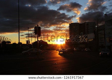 a beautiful city sunset with dark clouds above the road junction with many cars, signal lights in Melbourne city ,Australia ,taken during twilight