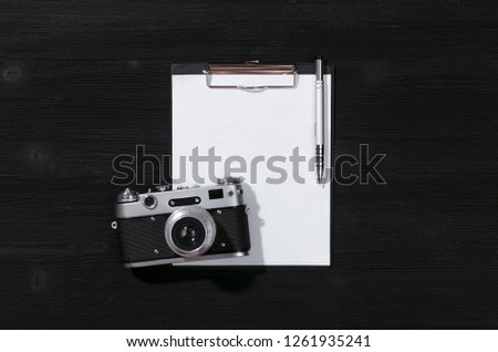 Shot list mockup. Photo session contract template. Vintage film photo camera and blank paper page on black wooden table background. Flat lay design.