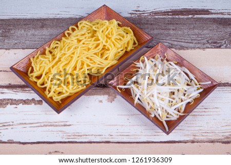 Yellow noodle and bean sprouts in wooden plate