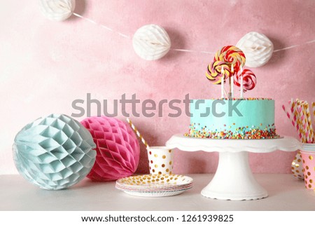 Stand with fresh delicious cake and birthday decorations on table. Space for text