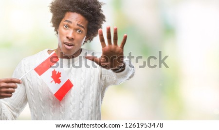Afro american man flag of Canada over isolated background with open hand doing stop sign with serious and confident expression, defense gesture