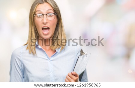 Young beautiful inspector business woman over isolated background scared in shock with a surprise face, afraid and excited with fear expression