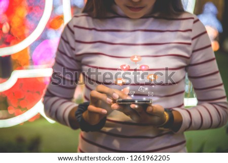 Close-up photos of a woman's hand using a smartphone at night on a shopping street in the city. Search or social networking concept. Hipster Prints SMS Text Messages to His Friends - Pictures and Idea