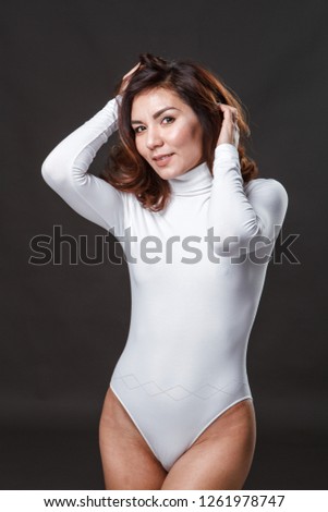 Beautiful girl in swimsuit posing against  grey white  background
