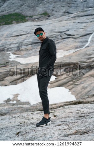 portrait of young traveler rock climber on the background of spellbinding landscape of Norwegian nature with high charming mountains and hills in which it is impossible not to fall in love