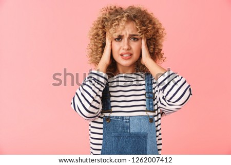 Photo of distressing curly woman 20s grabbing head isolated over pink background