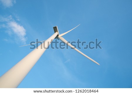View up, bottom view of wind turbine, windmill isolated on blue sky background. Royalty high-quality free stock photo image looking up wind turbine, windmill energy converter in a blue sky background