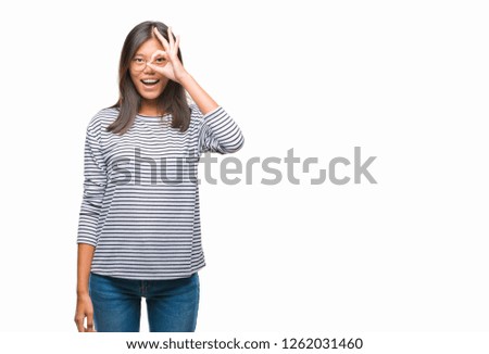 Young asian woman wearing glasses over isolated background doing ok gesture with hand smiling, eye looking through fingers with happy face.