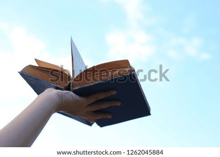 Close-up image of a hand holding an old book open selective focus and shallow depth of field