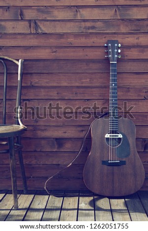 acoustic guitar on vintage wooden wall background ( white balance is incorrect)