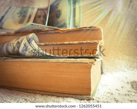 Knowledge leads to wealth. Old books and one hundred dollars