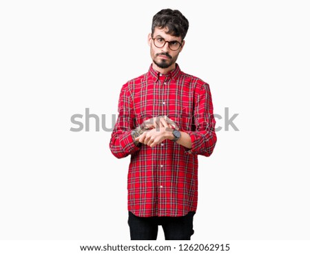 Young handsome man wearing glasses over isolated background In hurry pointing to watch time, impatience, upset and angry for deadline delay