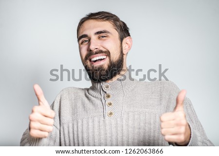 handsome bearded man showing sign of cool, like it, close-up on background