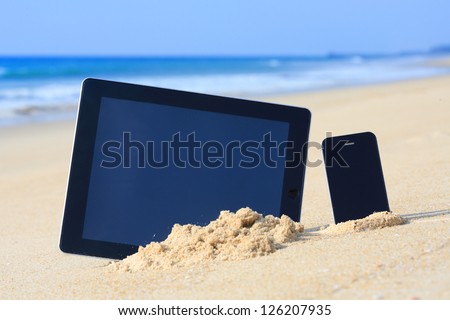 tablet computer and smartphone on the beach. Royalty-Free Stock Photo #126207935
