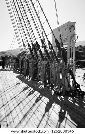 Ship with long ropes, cables, tackles and a wooden deck. Black and white photo