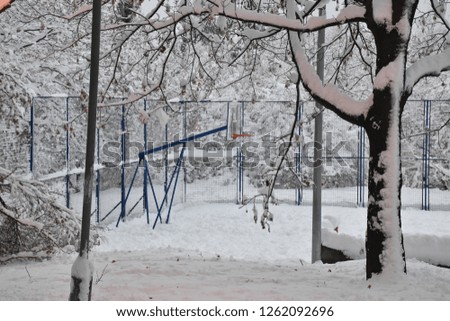 Outdoor basketball court covered in snow