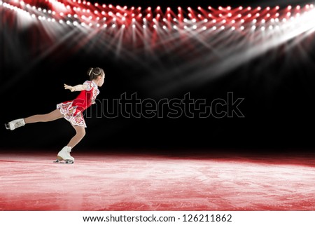 young skater performs on the ice in the background lights lighting