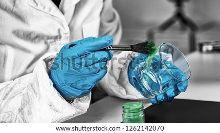 Forensic Evidence examination.  Police laboratory analyst examining glass from a crime scene, looking for fingerprints Royalty-Free Stock Photo #1262142070