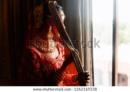 Indian wedding. Morning preparetions. Portrait of attractive Hindu bride with rich jewelry and deep dark eyes Royalty-Free Stock Photo #1262169238