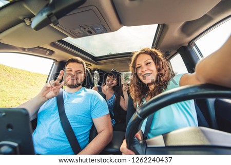 group of people taking selfie in car. car travel concept