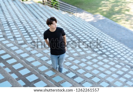 Handsome asian in black t shirt with jean man stand up on a staircase posing on grandstand background.
Portrait of young KOREAN against staircase background. Royalty-Free Stock Photo #1262261557