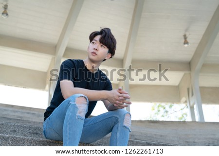 Handsome asian CASUAL man sit on a staircase posing on grandstand background.
Portrait of young KOREAN against staircase background. Royalty-Free Stock Photo #1262261713