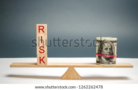 Dollars and the inscription "Risk" on the scales. The concept of financial risk and investing in a business project. Making the right decision. Property insurance. Legal and market risks