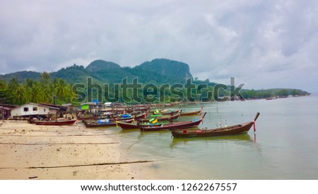 Island village by beach with long tail boats. Koh Mook, Thailand.