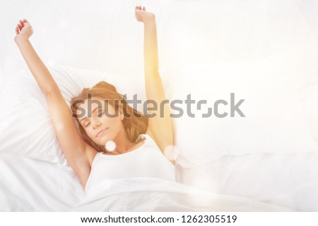 Young woman wakeup after sleeping on the white linen in bed at home