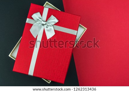 Open beautiful Red gift box with bow on black and grey background
