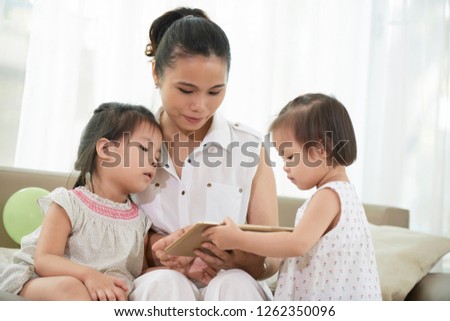Asian nurse and two little girls using application on tablet computer