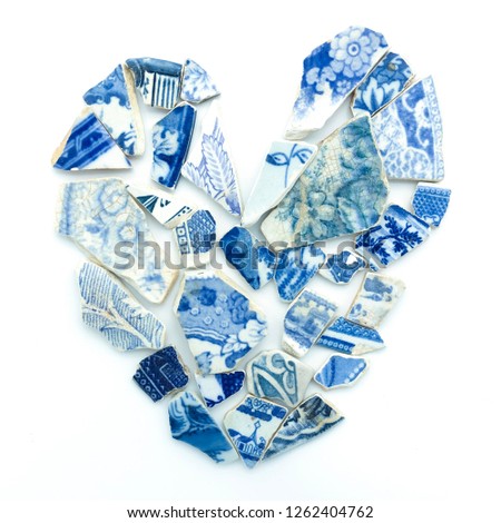 Broken heart pieces of blue white old mosaic tile fragments. Concept love hurt symbol, mend broken hearts, damaged, healing broken hearted. I love you romantic art wedding, st valentines, lovers day.