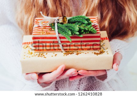 Woman's hands hold christmas or new year gift box.