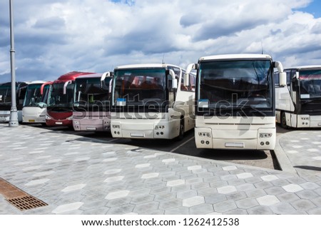 tourist buses on parking on the background of cloudy sky Royalty-Free Stock Photo #1262412538