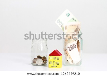 money in glass jar on table representing property purchase no people stock photo