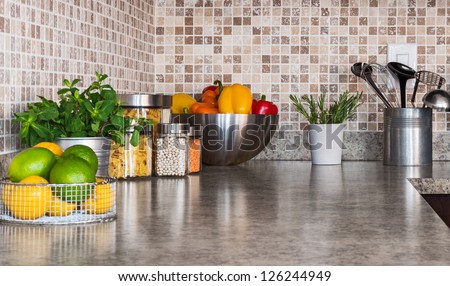 Modern kitchen countertop with food ingredients and green herbs. Royalty-Free Stock Photo #126244949
