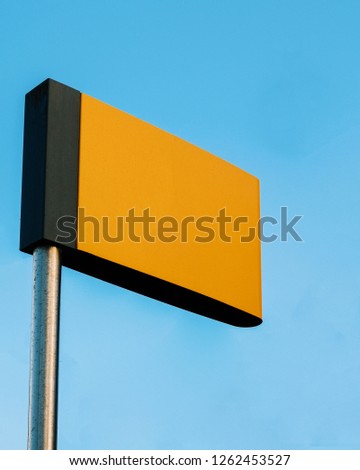 Blank Yellow Sign Against a Clear Blue Sky
