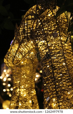 A night photograph of a deer statue made of yellow lights