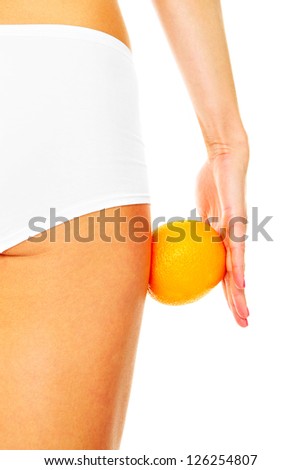 A picture of female legs and an orange over white background